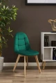 krzeslo-colin-tapicerowane-welurowe-zielone-w-pomieszczeniu.webp