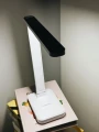 lampka-biurkowa-led-biala-na-ksiazkach-przy-lozku.webp