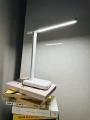 lampka-biurkowa-led-biala-swiecaca-na-stosie-ksiazek.webp